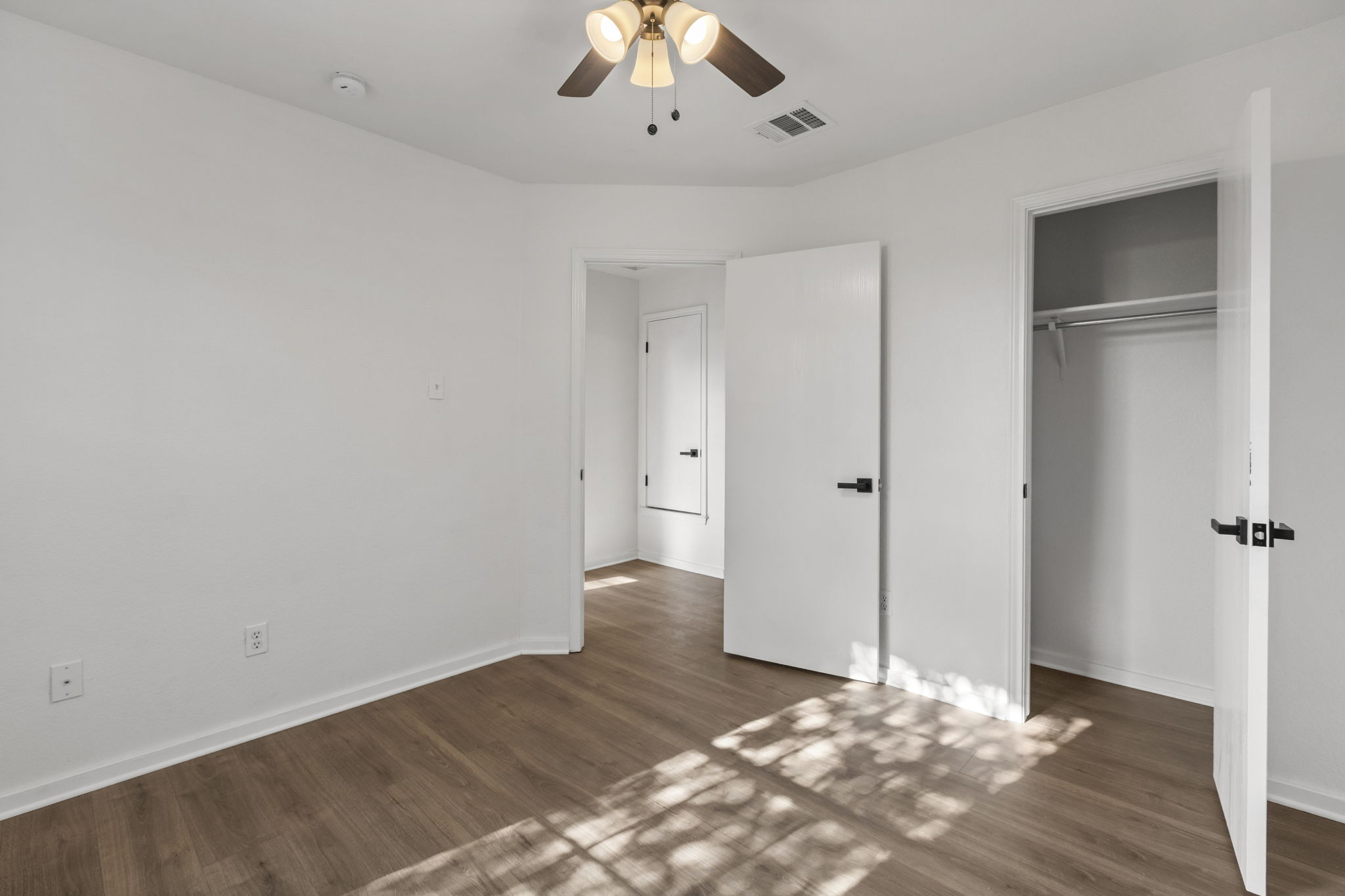 2110 Nogales Trail Austin, TX 78744 - Photo 27 of 36 Unfurnished bedroom featuring wood finished floors, ceiling fan, and a closet