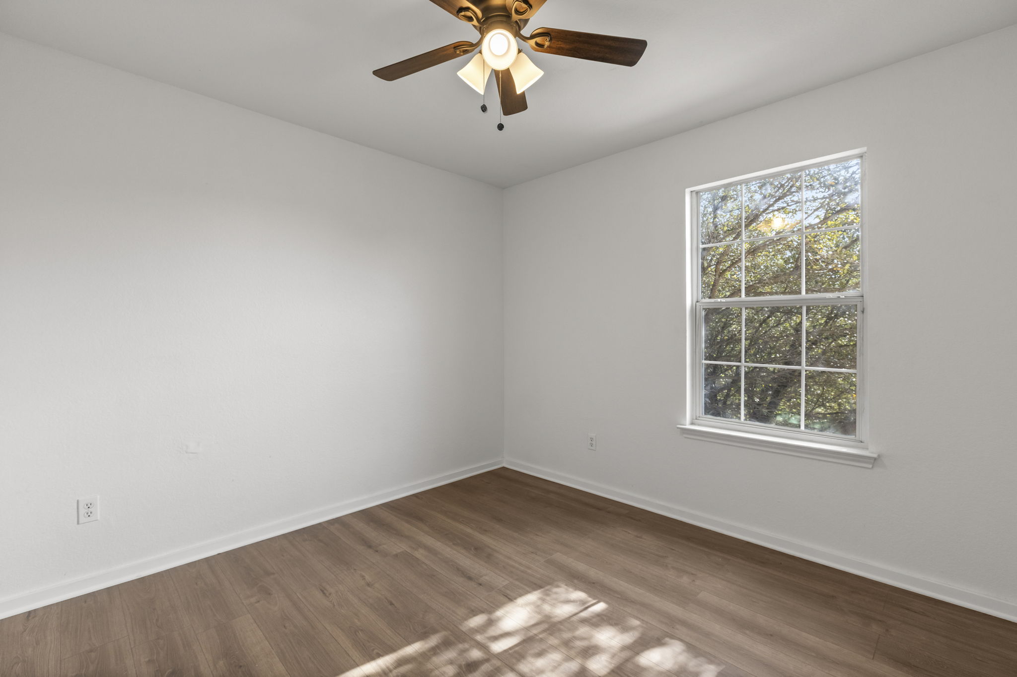 2110 Nogales Trail Austin, TX 78744 - Photo 28 of 36 Unfurnished room with wood-style flooring and a ceiling fan