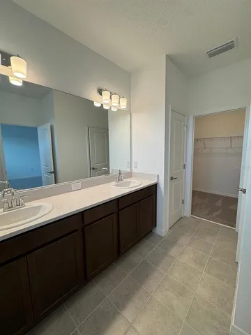 a spacious bathroom with a double vanity sink a mirror and a shower