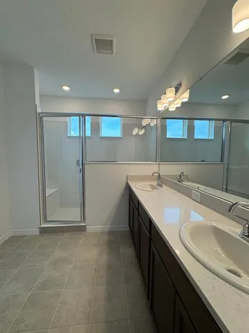 a bathroom with a granite countertop sink a mirror and a shower