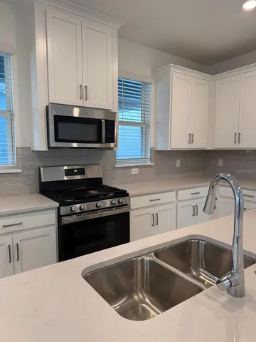 a kitchen with a sink and a stove top oven