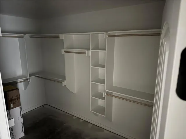 a view of walk in closet with empty racks
