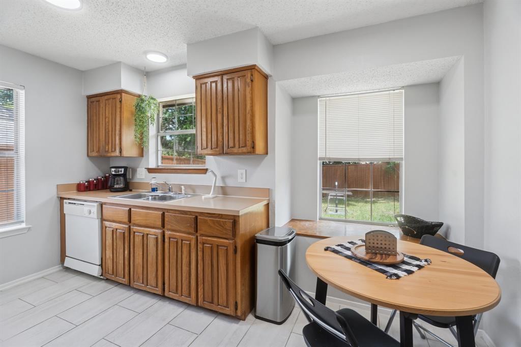9780 Windy Ridge Road Frisco, TX 75033 - Photo 7 of 25 Kitchen featuring light wood cabinetry, light countertops, and white appliances