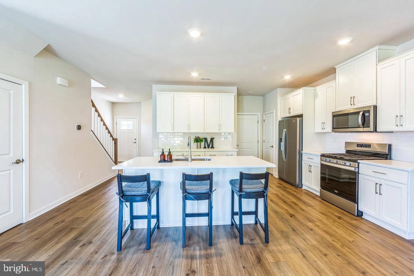 727 Hunsberger Road Spring City, PA 19475 - Photo 8 of 32 a kitchen with stainless steel appliances a dining table chairs stove refrigerator and microwave