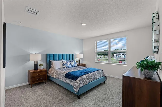 a bedroom with a bed lamp and a potted plant