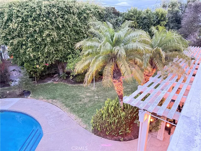 a view of backyard with swimming pool and seating space