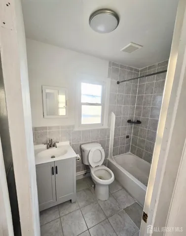 a bathroom with a toilet sink a mirror a bathtub and shower