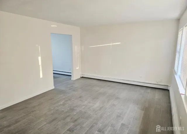 a view of an empty room and wooden floor