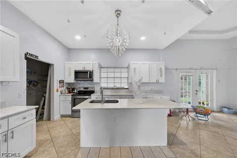a large kitchen with kitchen island a large counter space stainless steel appliances and cabinets