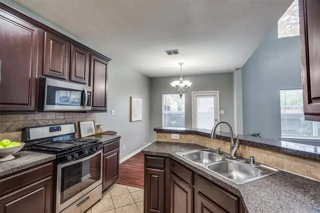 a kitchen with stainless steel appliances granite countertop a sink stove and cabinets