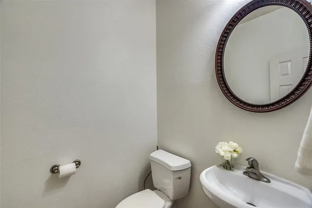 a bathroom with a sink mirror and toilet