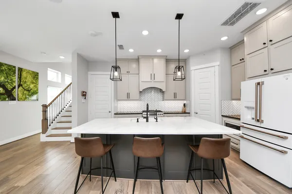 a kitchen with kitchen island a stove a sink a center island and a window