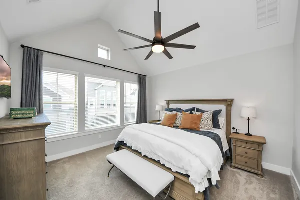 a spacious bedroom with a bed and a flat screen tv