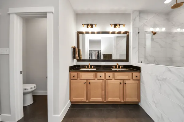 a bathroom with a granite countertop sink a large mirror and a shower