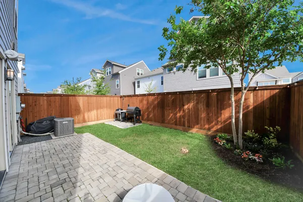 a view of a backyard with wooden fence and a bench
