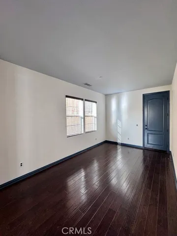 an empty room with window in back and closet area