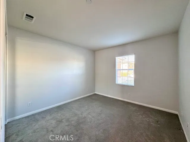 a view of an empty room with wooden floor and stairs