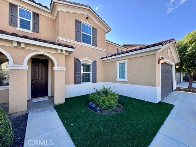 a front view of a house with a garden and plants
