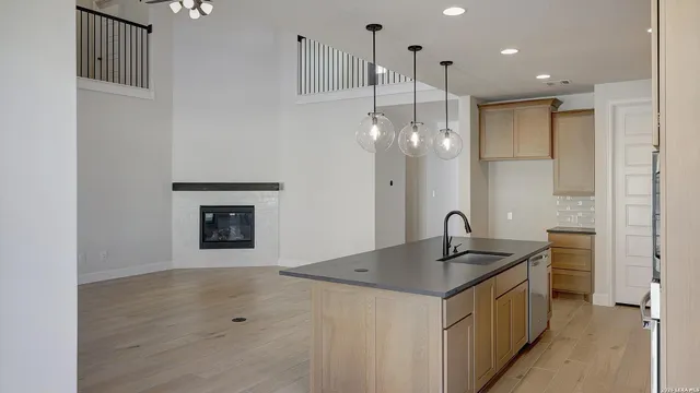 a kitchen with granite countertop a sink cabinets and stainless steel appliances