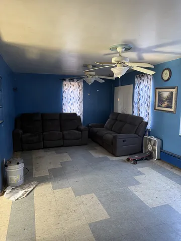 a living room with furniture a ceiling fan and a window