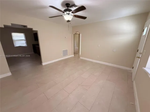 en empty room with windows and fan