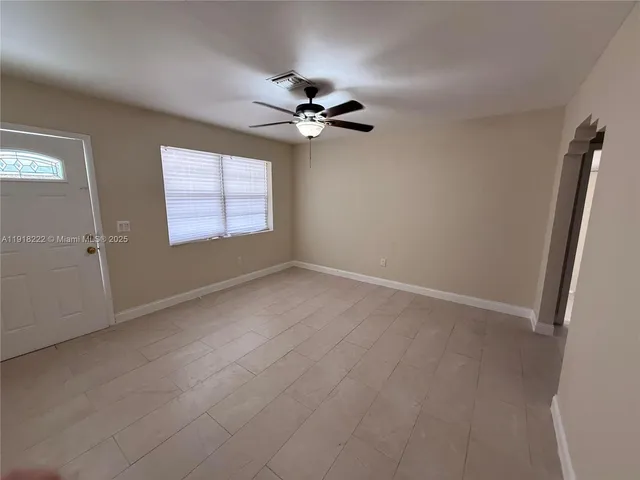 an empty room with windows and fan