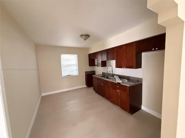 a kitchen with stainless steel appliances granite countertop a refrigerator a sink dishwasher a stove with wooden cabinets