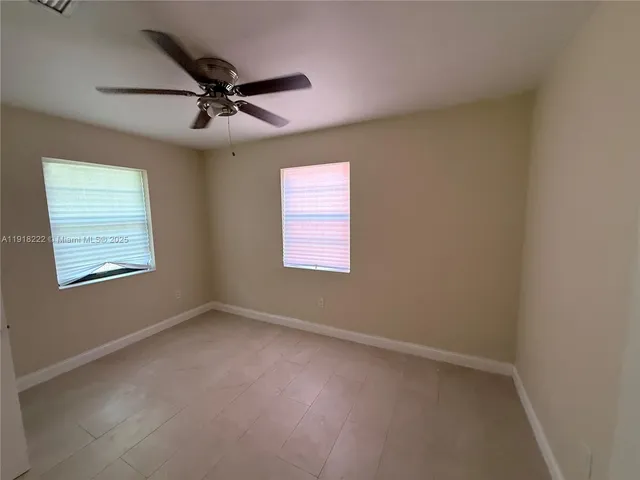 en empty room with windows and fan