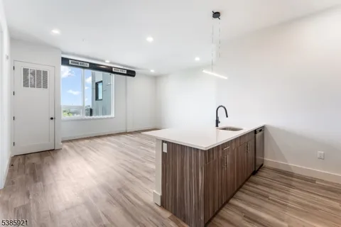 a view of a kitchen with sink and wooden floor
