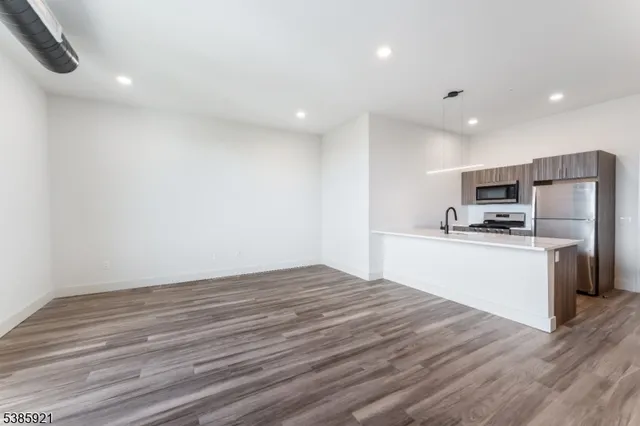 a kitchen with granite countertop stainless steel appliances a refrigerator sink and microwave