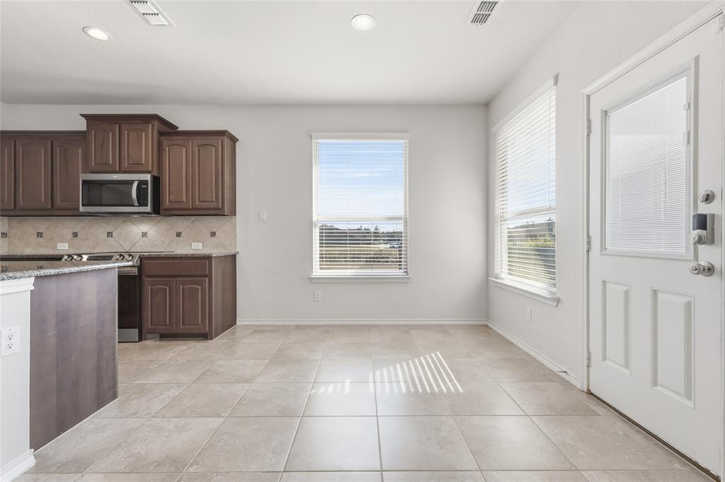 11301 Golden Ridge Lane Haslet, TX 76052 - Photo 12 of 35 a kitchen with stainless steel appliances granite countertop a stove a sink and a refrigerator