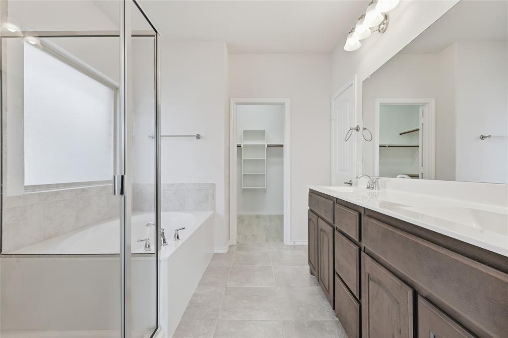 11301 Golden Ridge Lane Haslet, TX 76052 - Photo 19 of 35 a bathroom with a double vanity sink a mirror and a bathtub