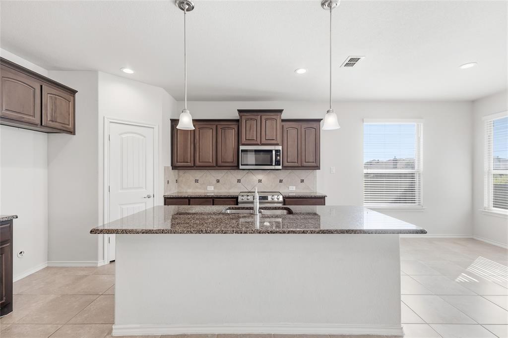 11301 Golden Ridge Lane Haslet, TX 76052 - Photo 10 of 35 a kitchen with granite countertop a stove a sink and a granite counter top