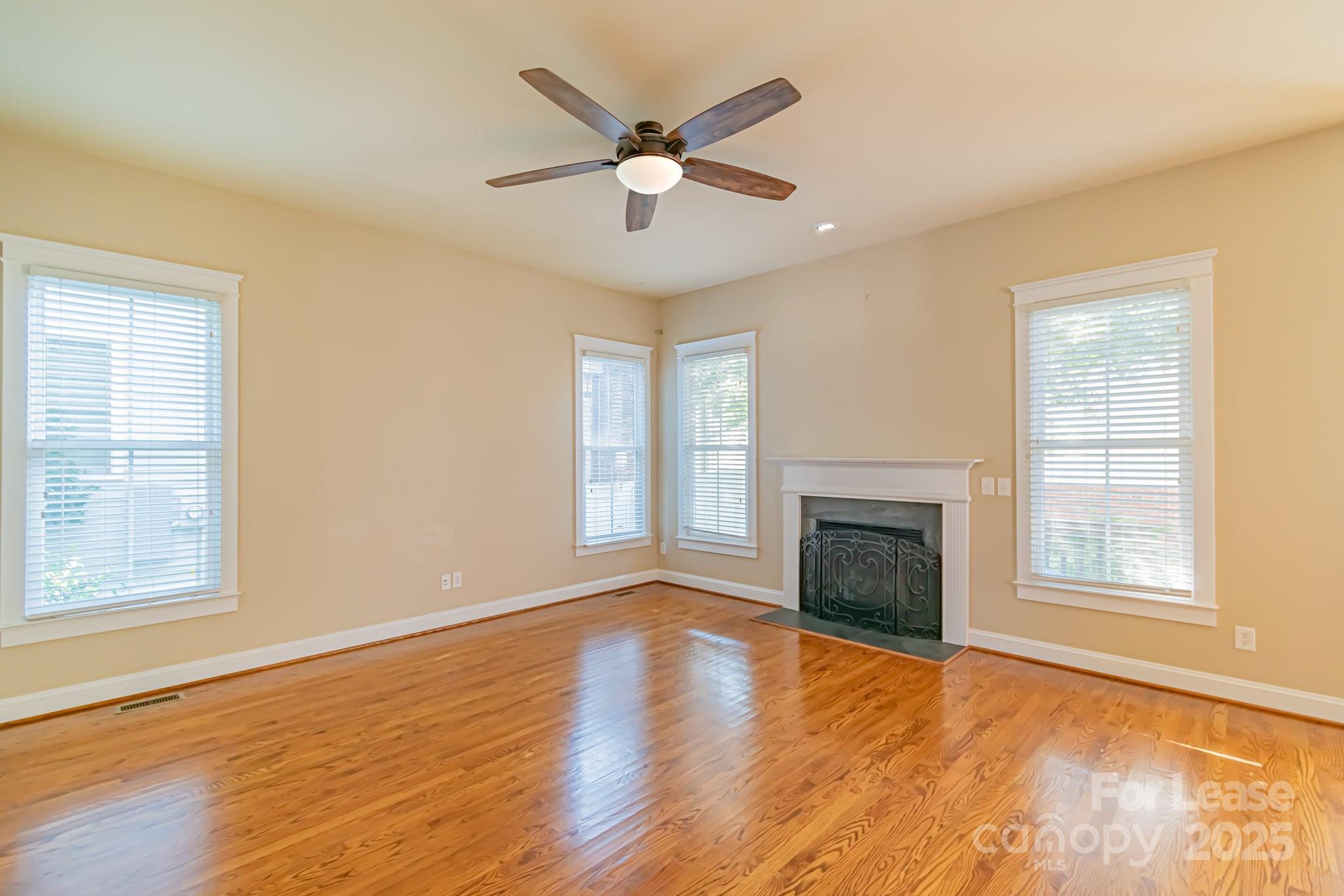 742 Revival Row Fort Mill, SC 29708 - Photo 11 of 32 an empty room with wooden floor fireplace and windows