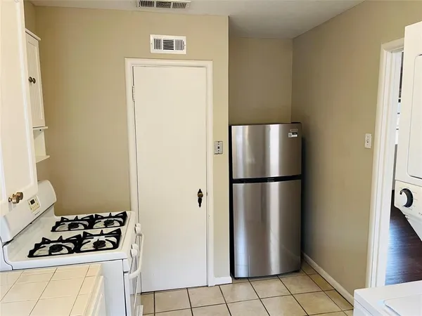 a white refrigerator freezer and a stove sitting inside of a kitchen
