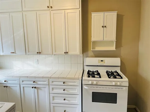 a white stove top oven sitting inside of a kitchen