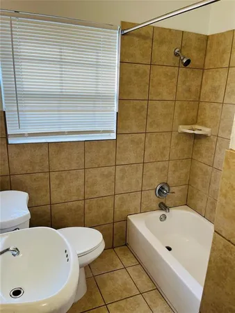 a bathroom with a sink and mirror with bathtub