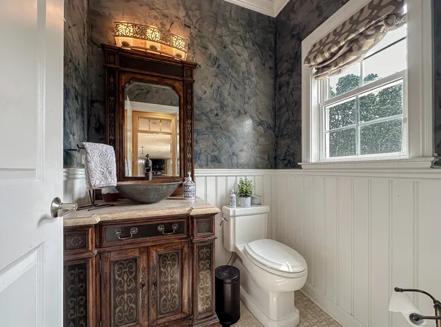 a bathroom with a toilet a sink and a mirror