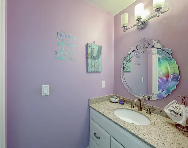 a bathroom with a granite countertop sink and a mirror