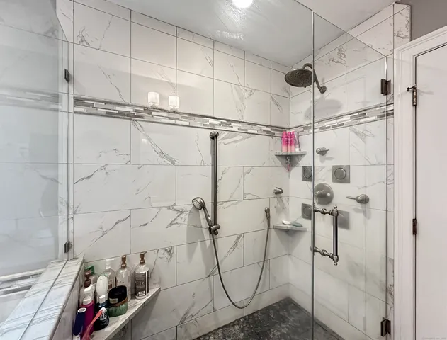 a spacious bathroom with a granite countertop sink a mirror and shower