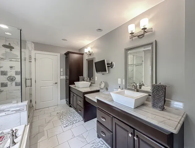a bathroom with a tub double vanity sink and mirror