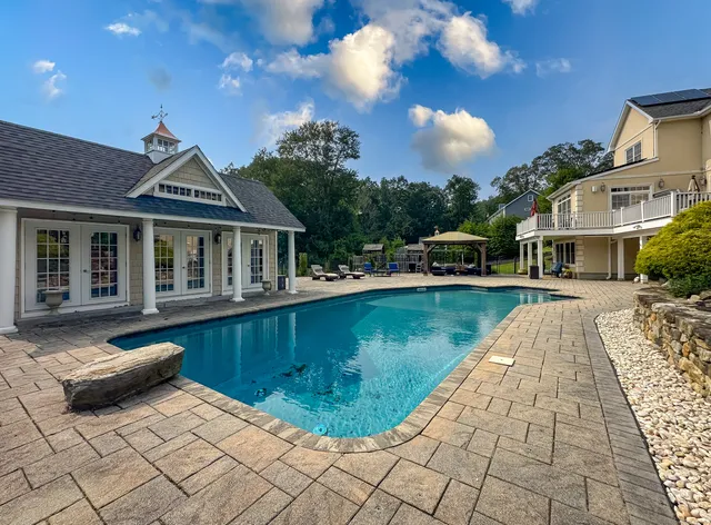an aerial view of a house with swimming pool garden and patio