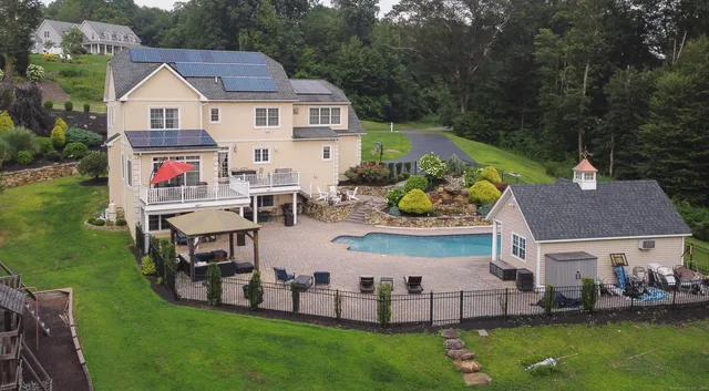 an aerial view of a house with outdoor space pool seating area and yard