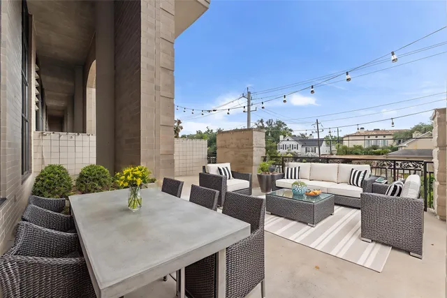 a view of a patio with couches chairs potted plants and city view