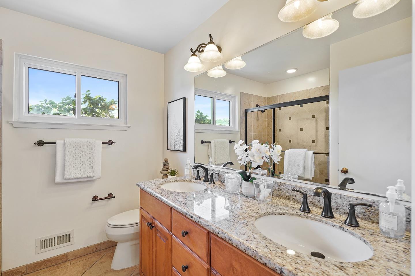 2805 Rivera Drive Burlingame, CA 94010 - Photo 17 of 28 a bathroom with a granite countertop sink a toilet and a mirror