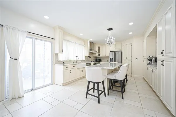 a kitchen with granite countertop a sink white cabinets and stainless steel appliances