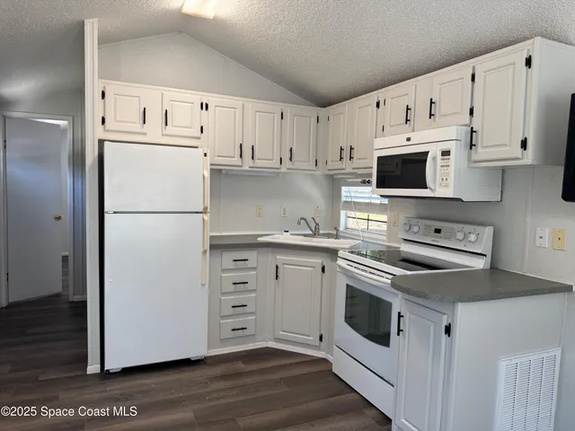 a kitchen with cabinets stainless steel appliances and a counter space