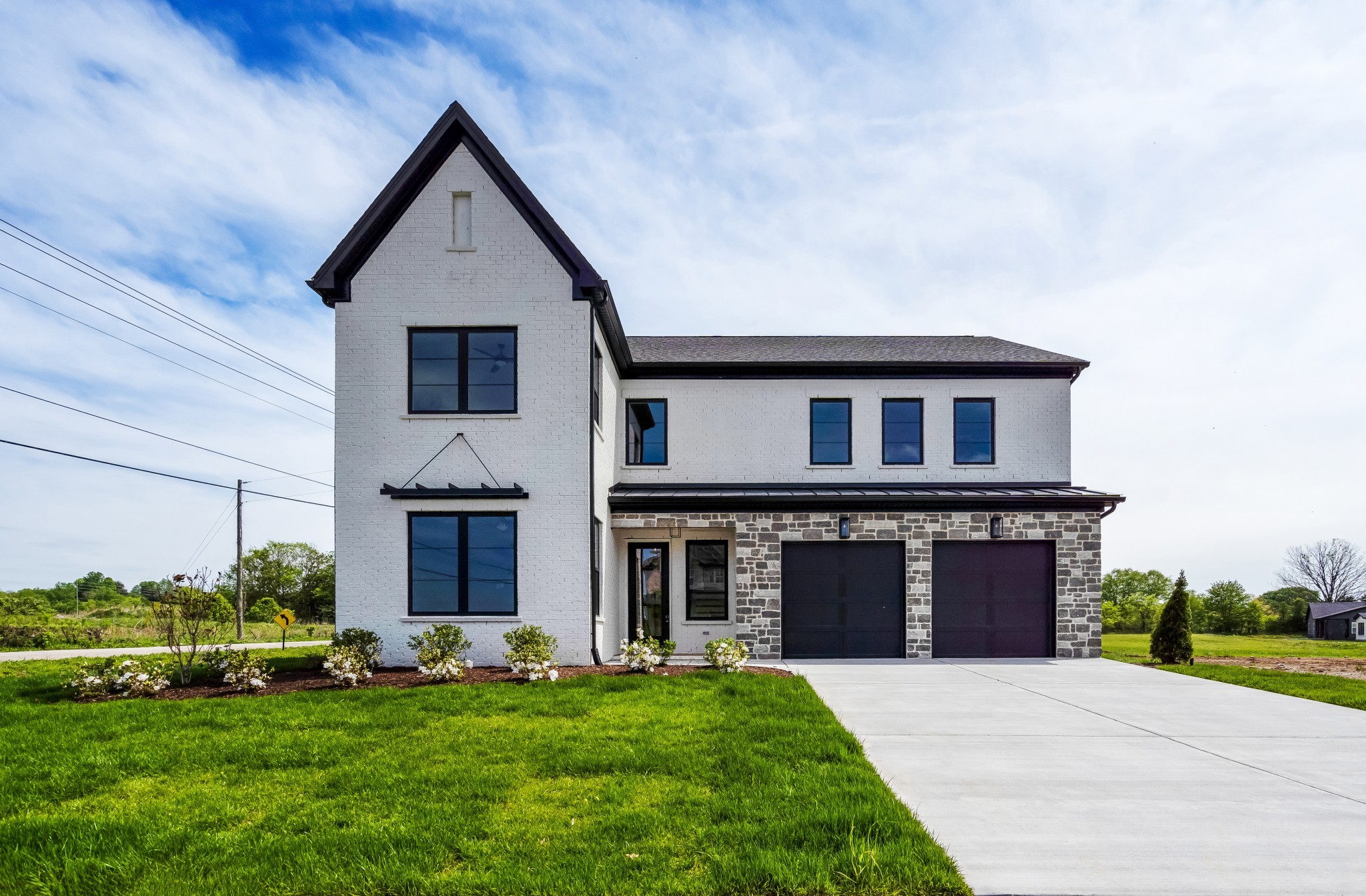 a front view of a house with a garden and yard