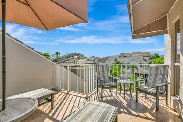 a view of a balcony with chair and wooden floor