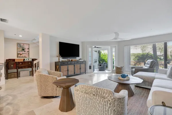 a living room with furniture a flat screen tv and a floor to ceiling window